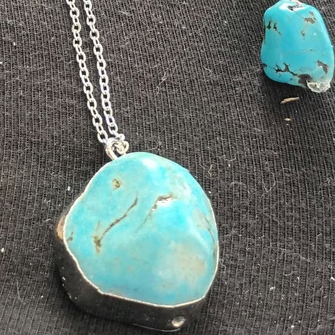 Large turquoise stone set in silver on a chain, with turquoise drop earrings